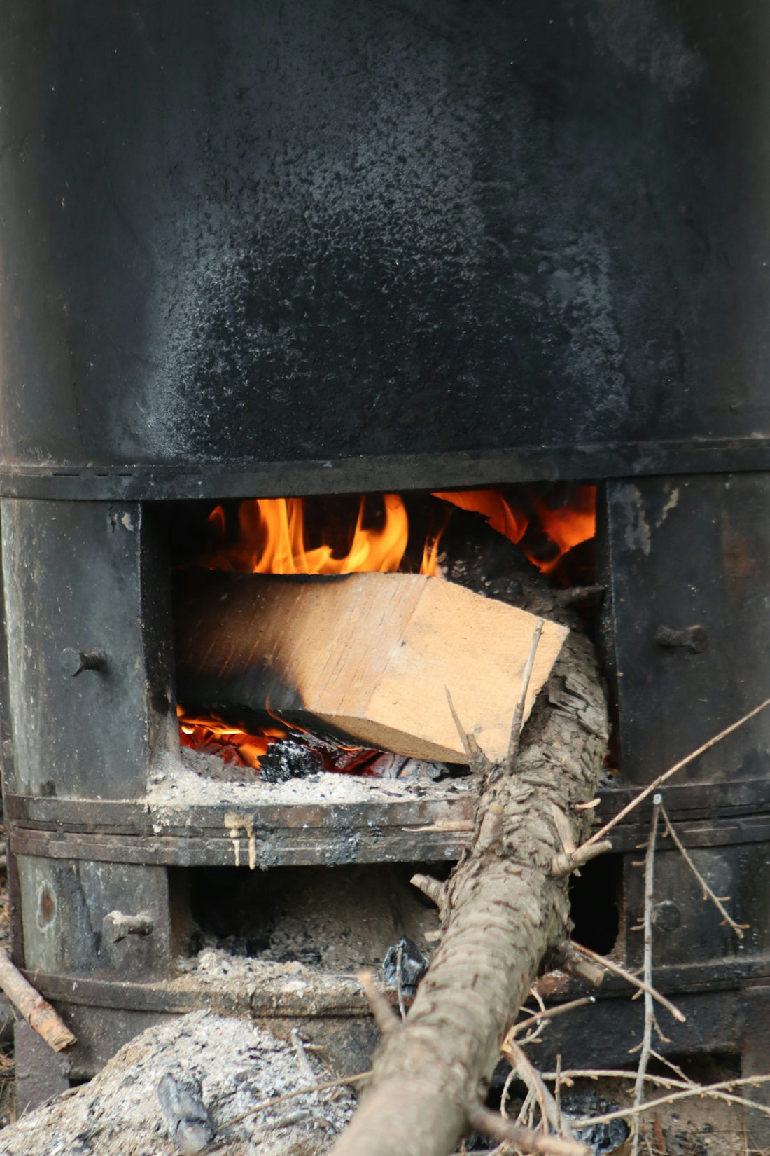 A fire burning inside of a black stove